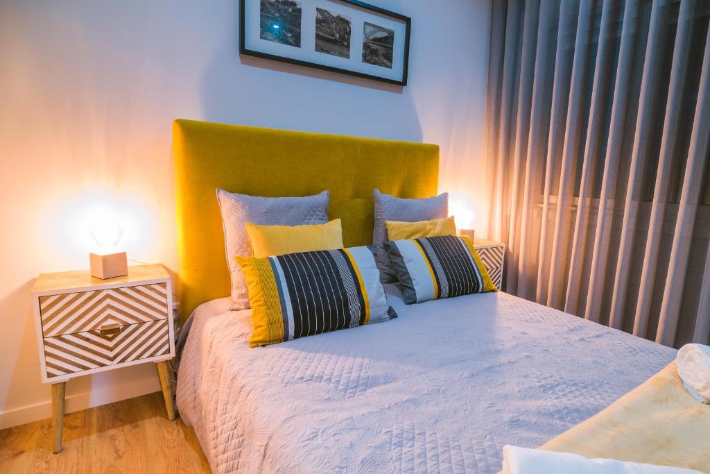 1 dormitorio con 1 cama con cabecero verde y almohadas en Lechartier Oporto apartments 3, en Oporto