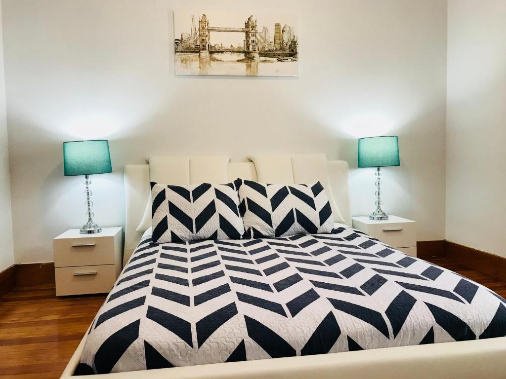 a bedroom with a black and white bed and two lamps at Boston Lodge and Suites in Boston