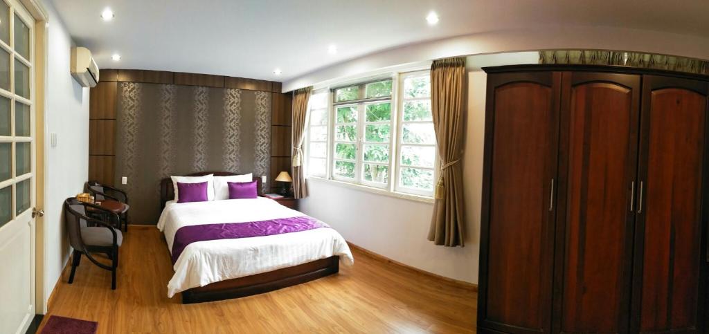 a bedroom with a bed with purple pillows and a window at Nancy Bridge View A1206 in Ho Chi Minh City