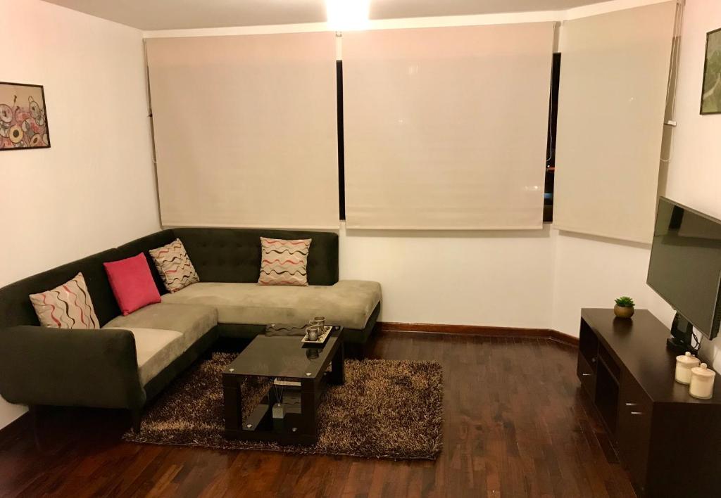sala de estar con sofá y mesa en Departamento completo en San Borja, en Lima