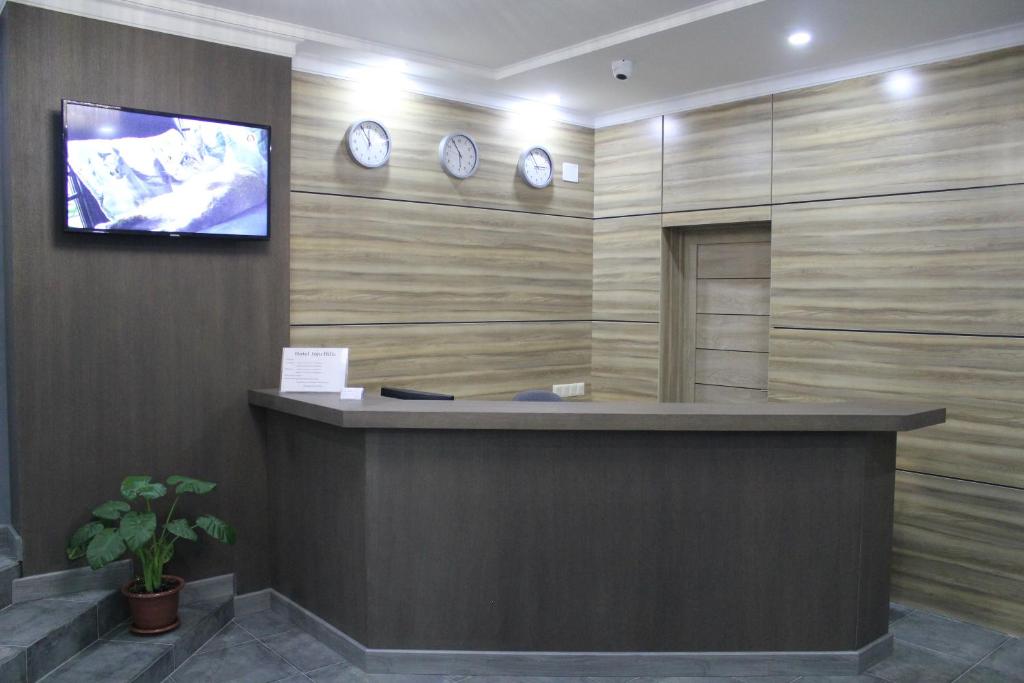 a lobby with a reception desk with clocks on the wall at Hotel Inju Hills in Astana