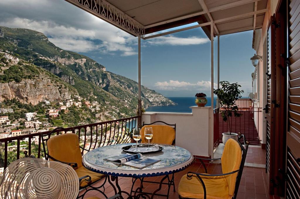 balcone con tavolo, sedie e vista sull'oceano di Casa Le Terrazze a Positano