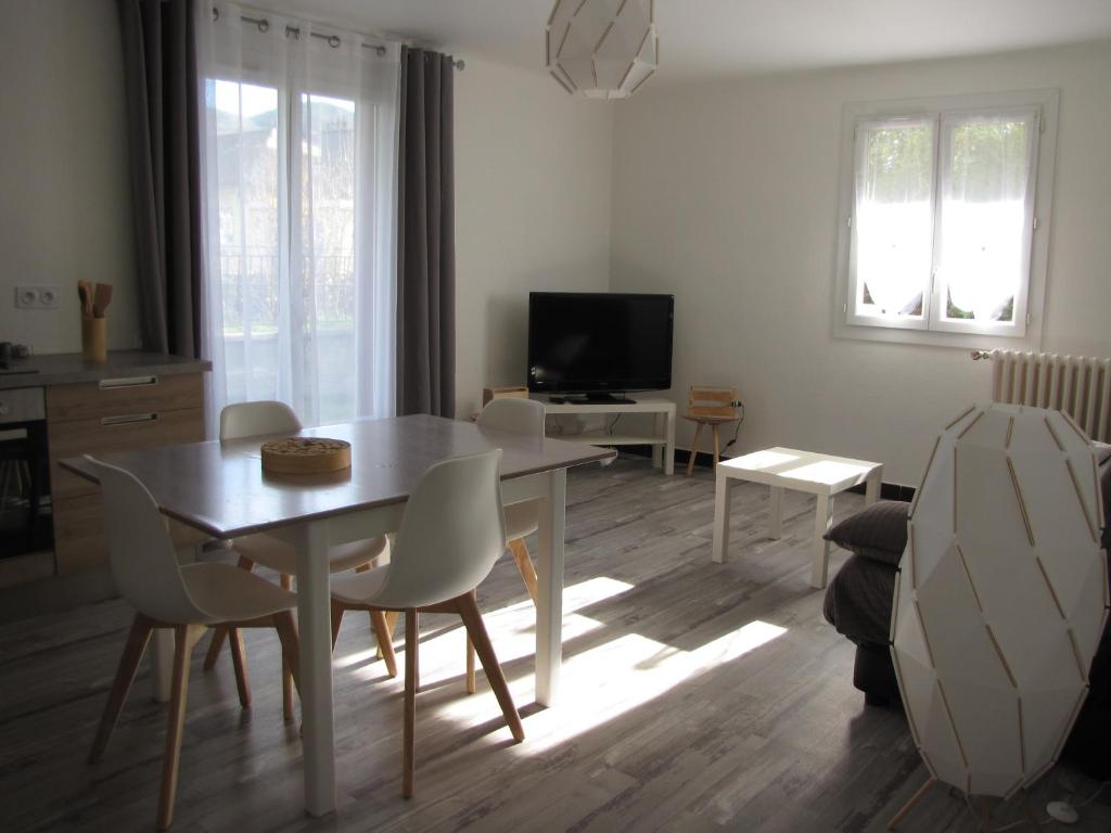 - un salon avec une table, des chaises et une télévision dans l'établissement BdB nid douillet au rdc rando ressourçante, à Bagnères-de-Bigorre