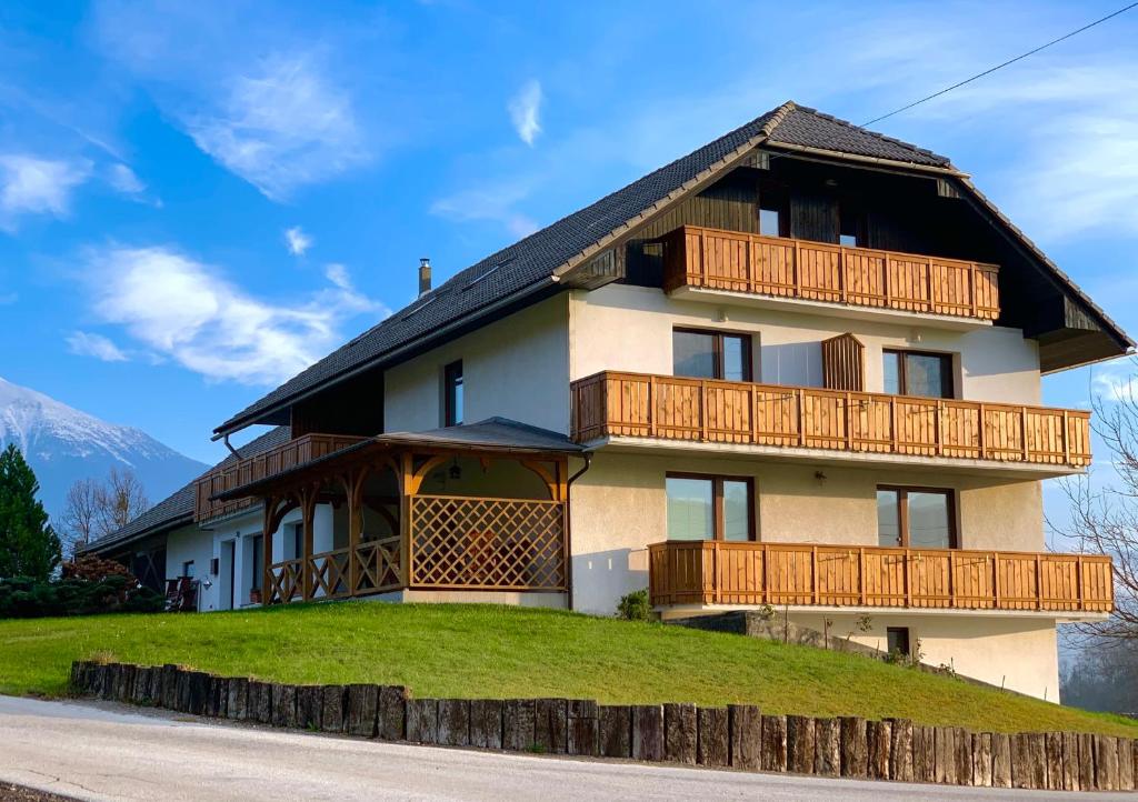 a house on a hill with wooden balconies at Apartments-Rooms Kocijancic in Bled