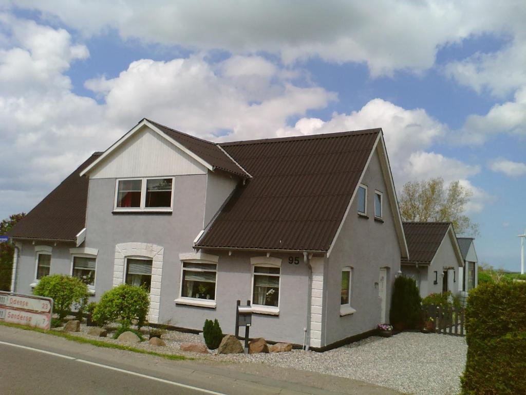 a white house with a brown roof at Svalegaarden Guesthouse in Særslev