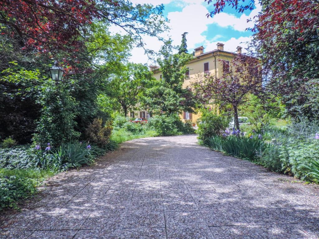 una carretera que conduce a una casa con flores y árboles en Villa Brizzi, en San Lazzaro di Savena