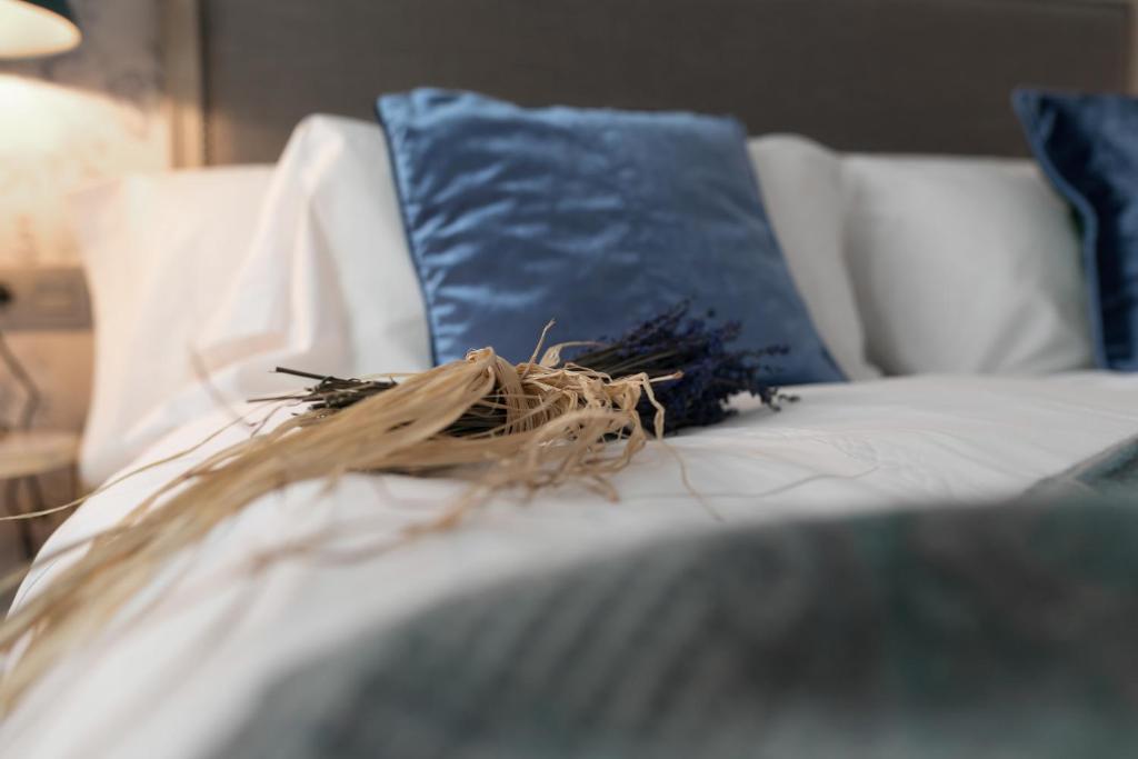 una almohada azul sentada en un sofá blanco con una almohada azul en San Jerónimo 17 Suites en Granada