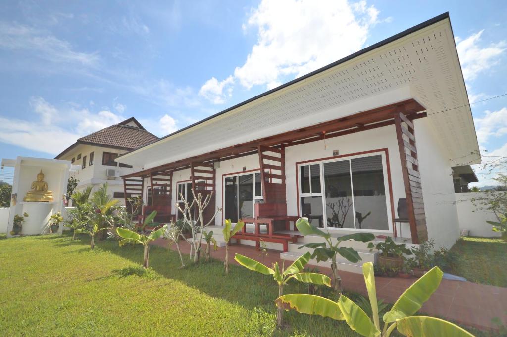 une maison avec une pelouse devant elle dans l'établissement Mrchu Meditation House, à Khao Lak