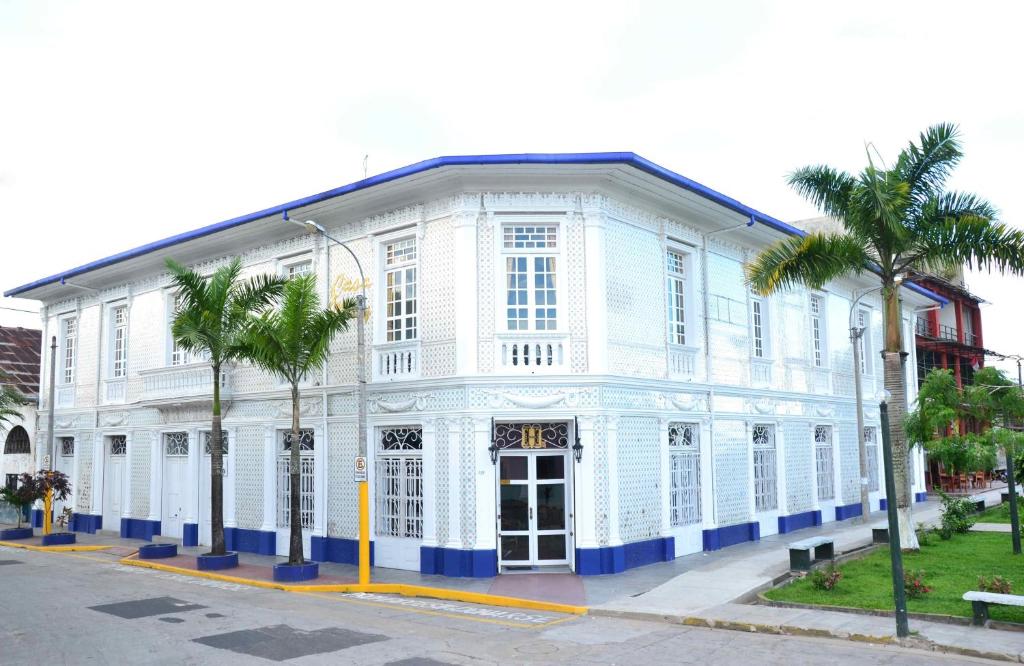 a white building with palm trees in front of it at Casa Morey in Iquitos