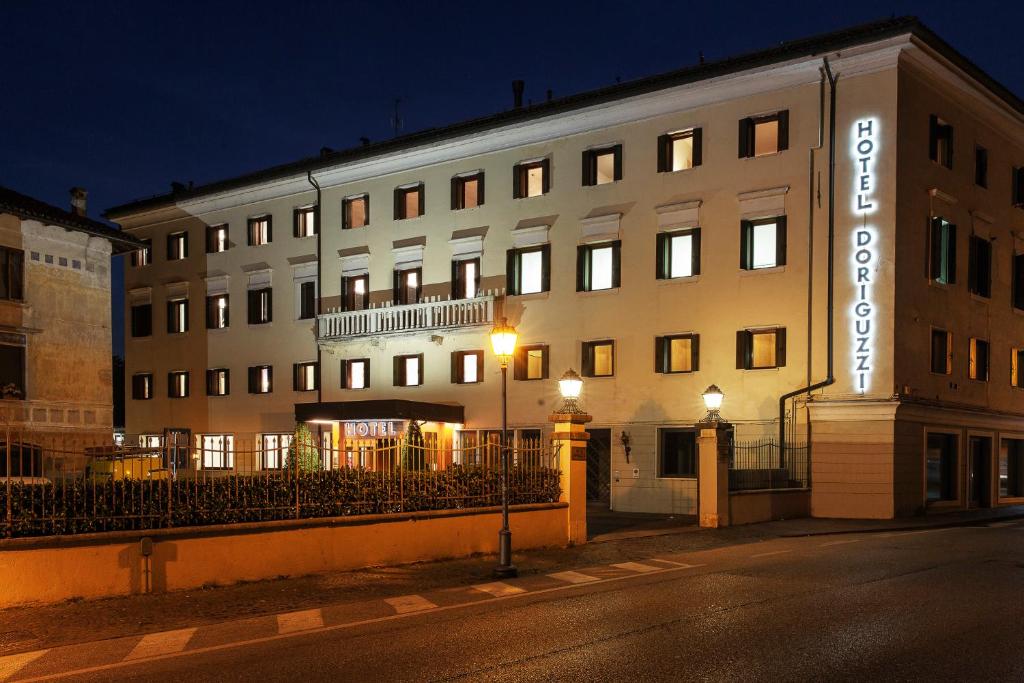 a building with a lit up sign on the side of it at Hotel Doriguzzi in Feltre