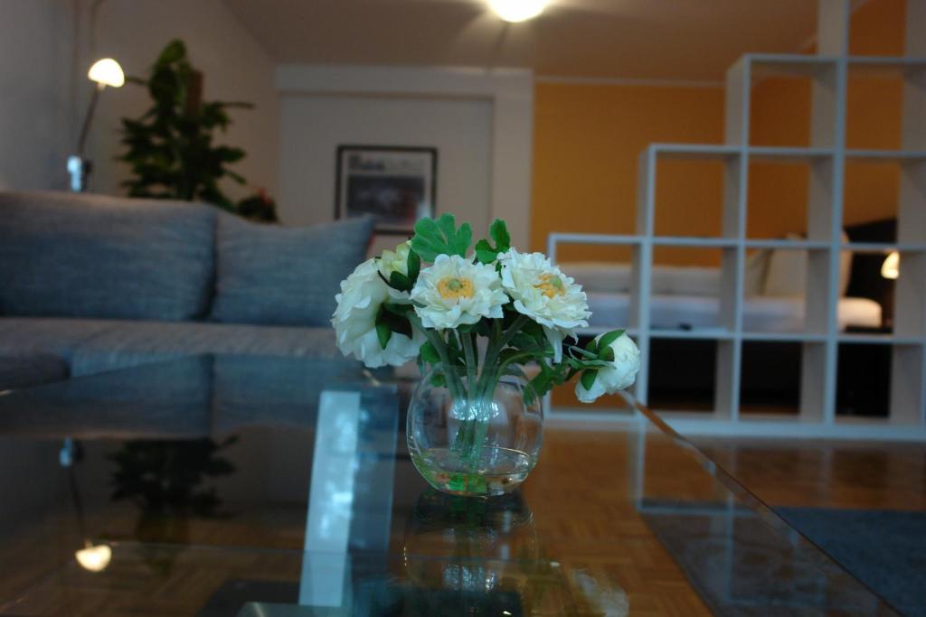 a vase with white flowers sitting on a glass table at Pension Zeitlos in Potsdam