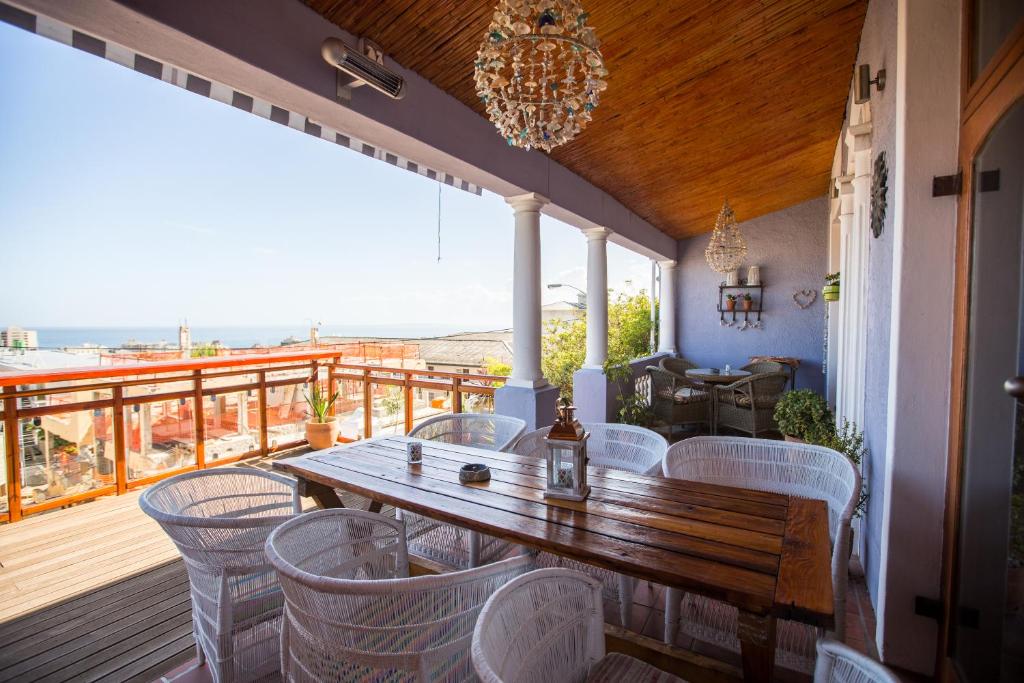porche con mesa de madera y sillas en la cubierta en Sweetest Apartments, en Ciudad del Cabo