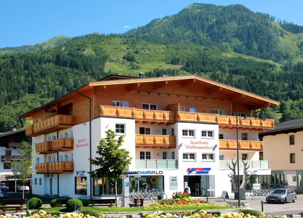 ein großes Gebäude mit einem Berg im Hintergrund in der Unterkunft Aparthotel Waidmannsheil in Kaprun