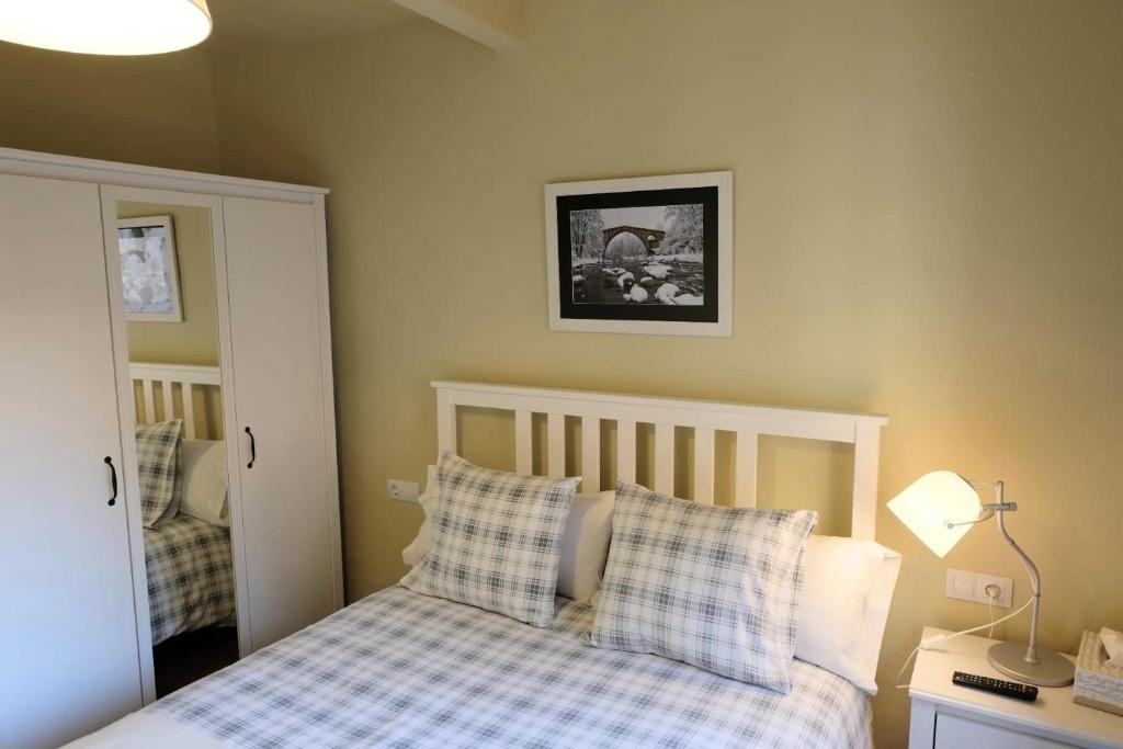 a bedroom with a bed with checkered pillows at Apartaments Sant Miquel in Sant Joan de les Abadesses