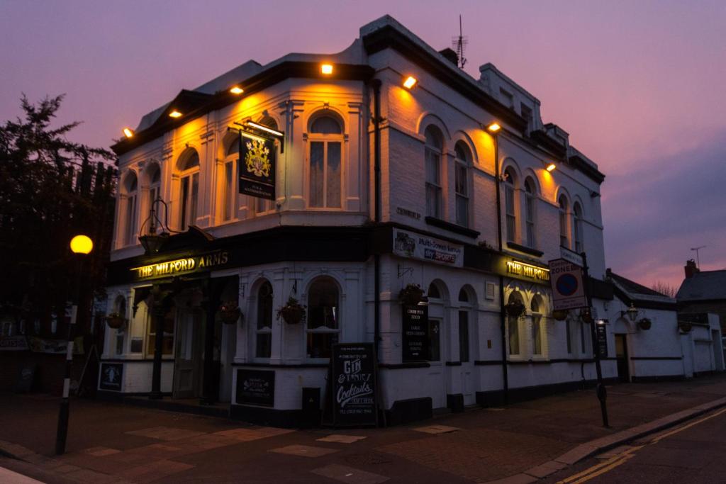 ein großes weißes Gebäude mit Lichtern darüber in der Unterkunft The Milford Arms in Hounslow