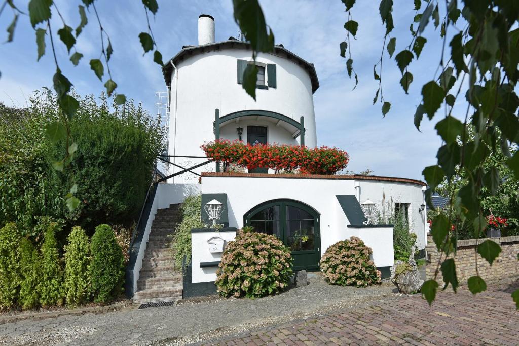 a white house with a window with flowers on it at De Witte Molen Kranenburg in Kranenburg