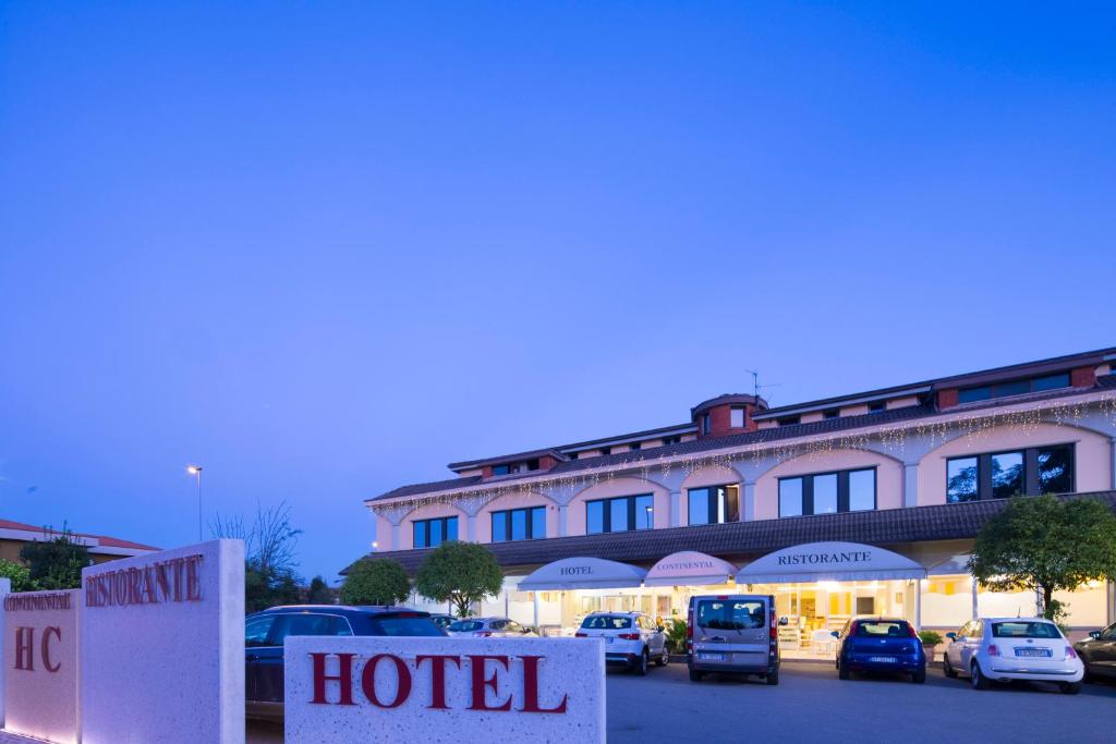 a hotel with cars parked in a parking lot at Hotel Ristorante Continental in Osio Sotto