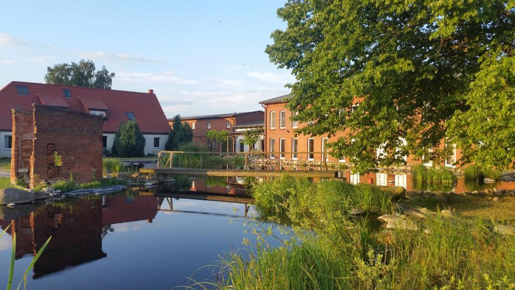 a river in front of a building with a bridge at Landhotel kreien in Kreien