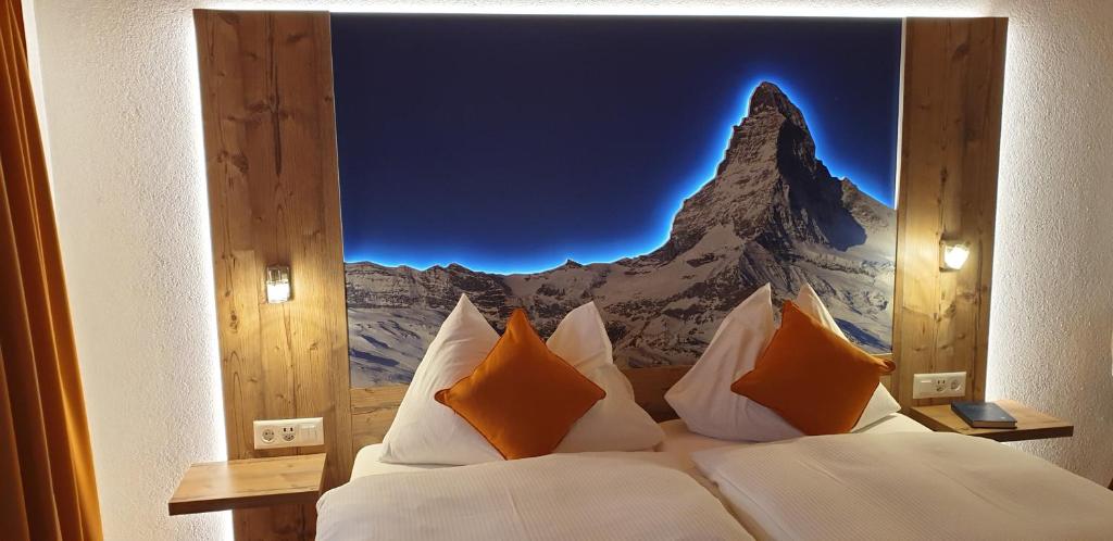 a bedroom with a mural of a mountain at Typically Swiss Hotel Täscherhof in Täsch