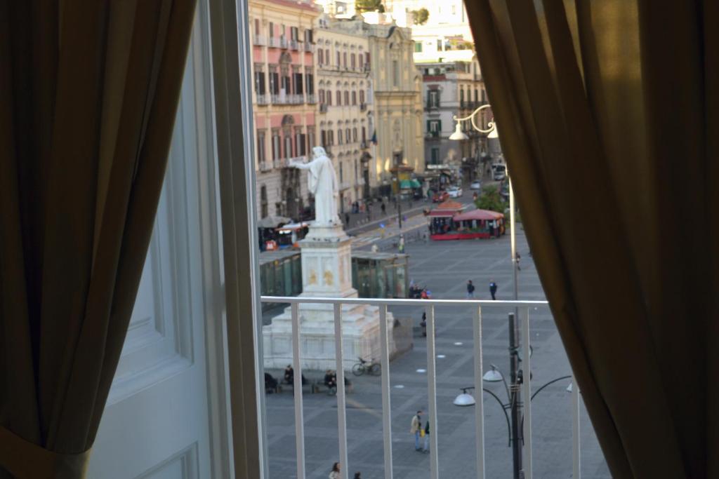 a view from a window of a city with a statue at Il Viaggio di Dante Historical Center in Naples