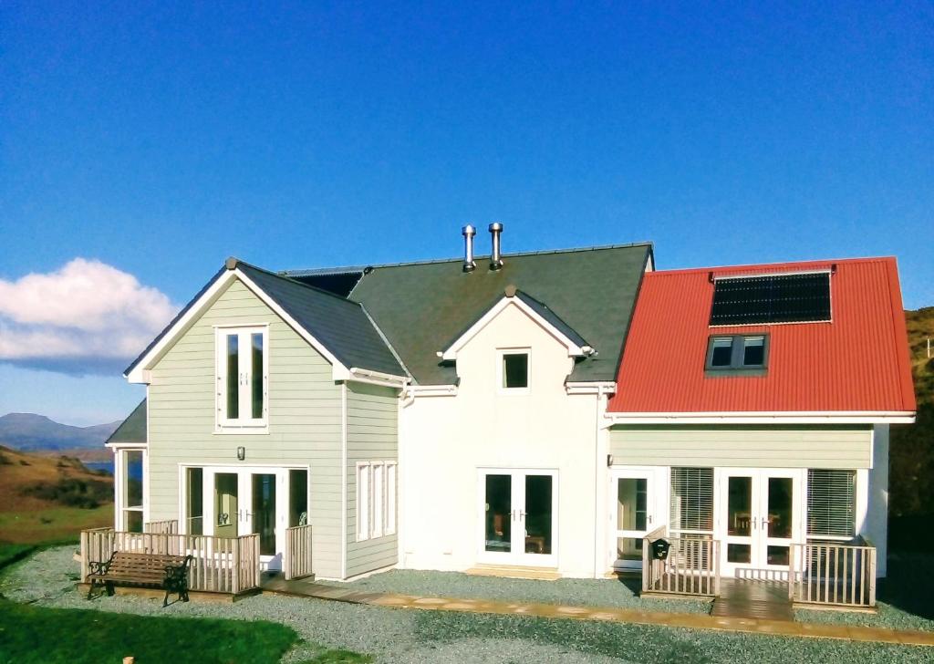 een groot wit huis met een rood dak bij Garroch House in Carbost