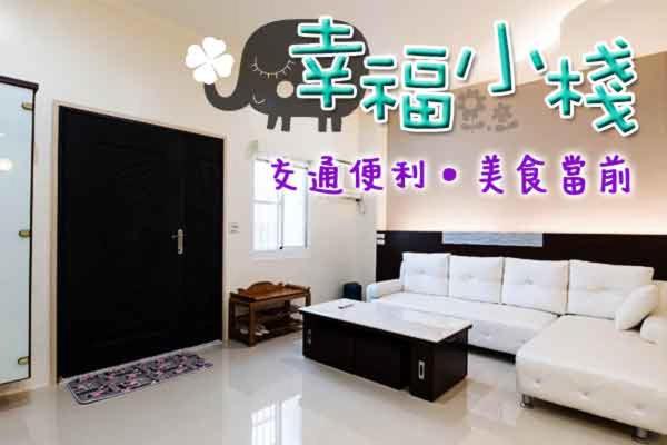 ein Wohnzimmer mit einem Sofa und einem Elefanten an der Wand in der Unterkunft Happiness B&B in Linbian