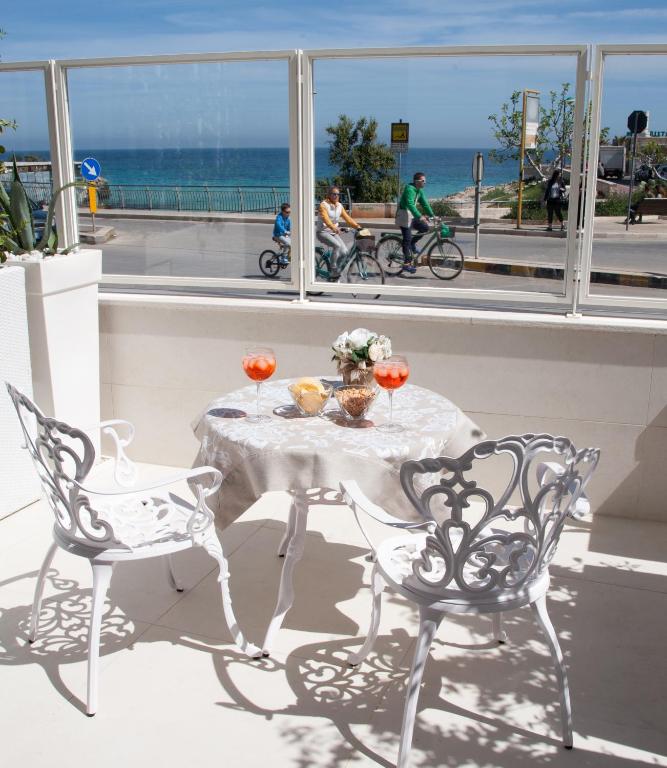a table and chairs on a balcony with a view of the ocean at Bellariva Monopoli B&B e Relax in Monopoli