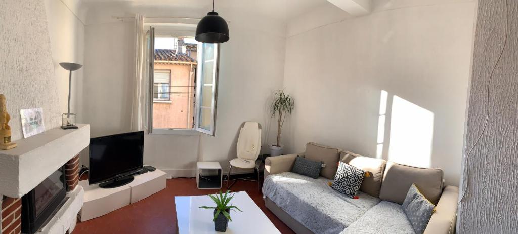 a living room with a couch and a tv at Studio Calendal in Cassis