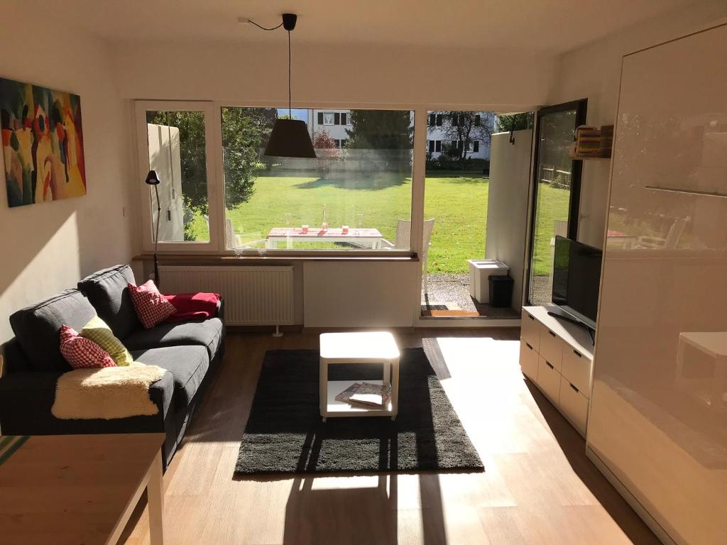 a living room with a couch and a large window at Central Garden-Mountain Apartment in Garmisch-Partenkirchen