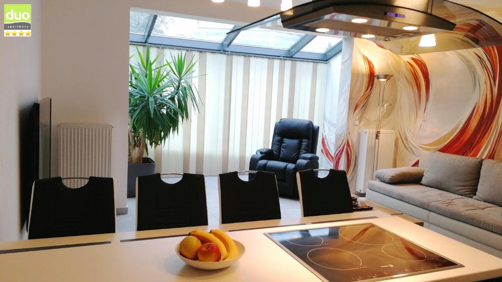 a living room with a couch and a bowl of fruit on a table at Apartmány Duo in Dačice