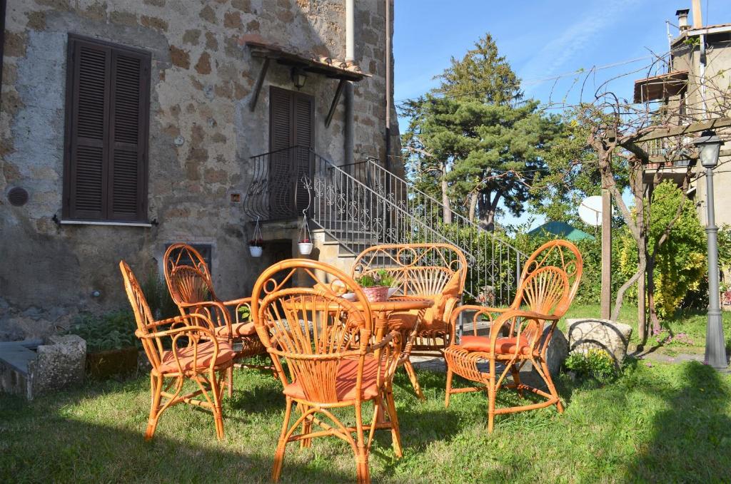 un grupo de sillas y mesas frente a un edificio en Il giardino di Elena, en Bagnoregio