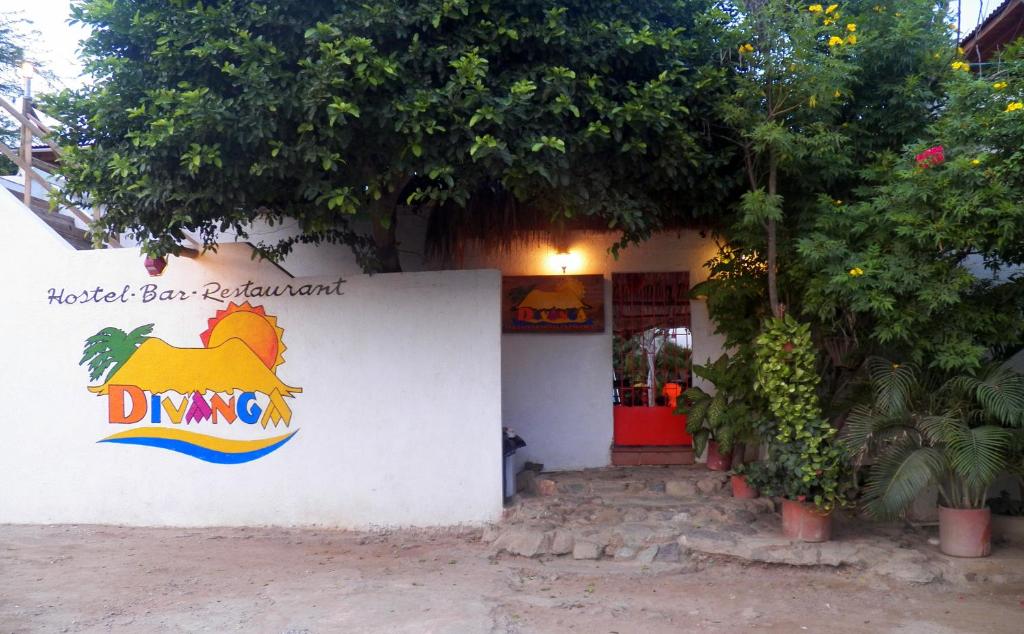 an orange and white building with a sign on it at Divanga Hostel in Taganga