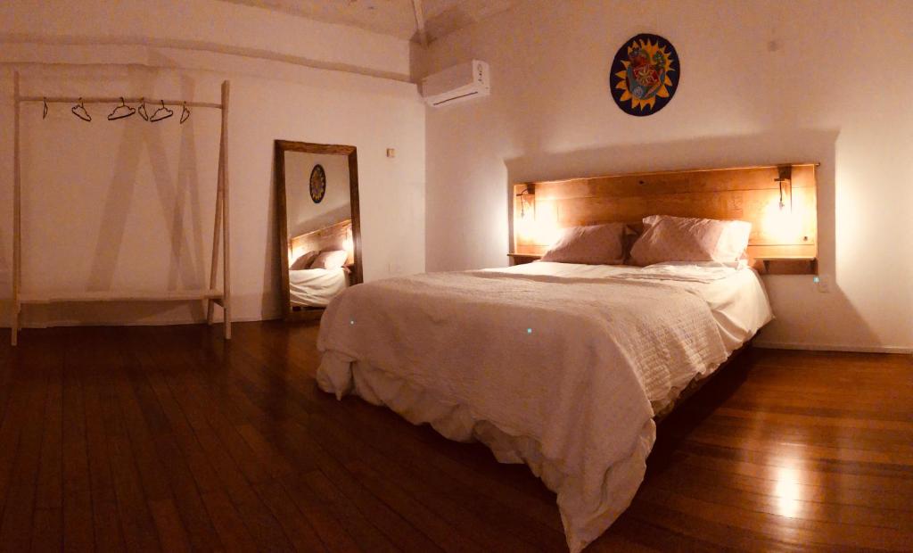 1 dormitorio con 1 cama grande y espejo en Las grutas Punta del este, en Punta del Este
