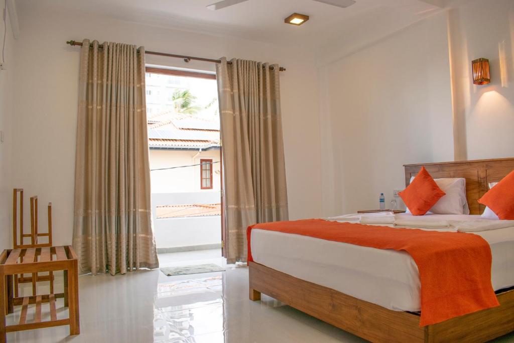 a bedroom with a bed and a large window at Lavinia Escapes in Mount Lavinia