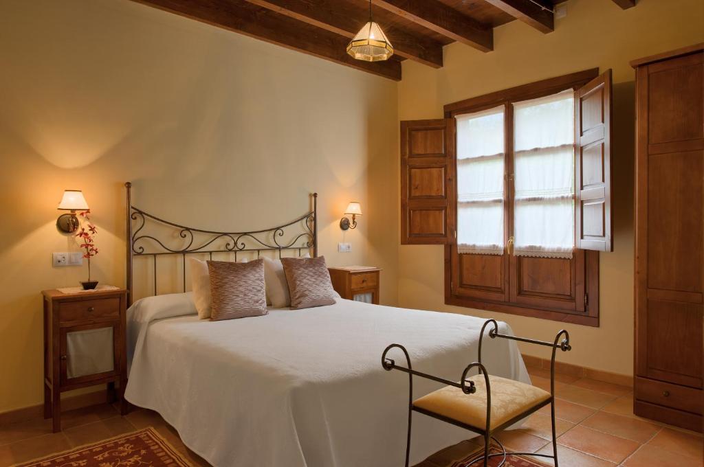 a bedroom with a bed and a window at El Molín de Petra in Valbucar