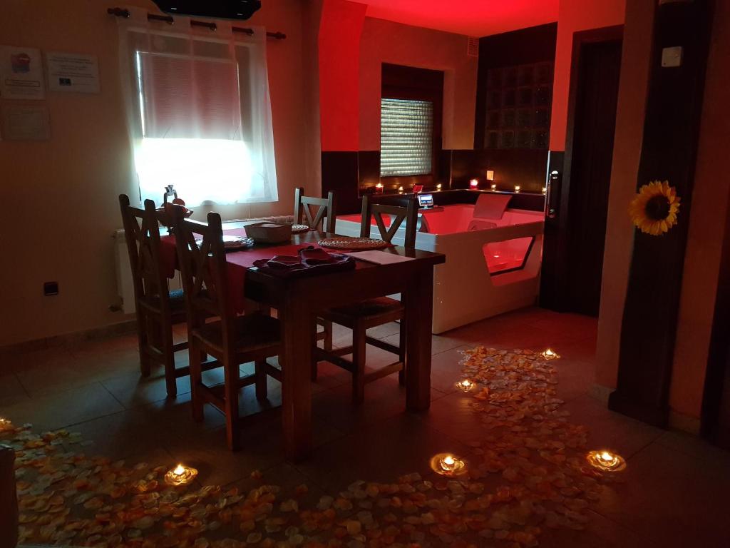 a dining room with a table and chairs with candles at Apartamentos Fuentevieja in Arbancón