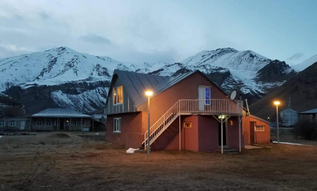 ein Haus mit einer Treppe vor einem Berg in der Unterkunft Little Star in Kazbegi