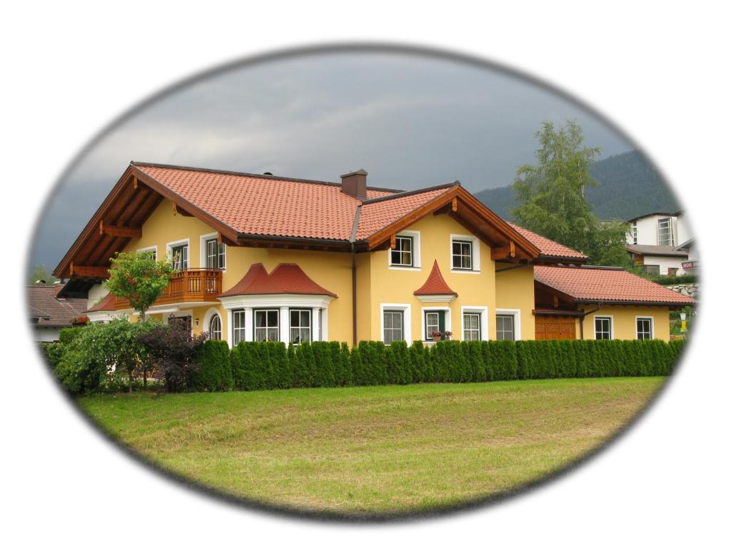 a yellow house with a red roof viewed through a mirror at Taurachblick in Radstadt