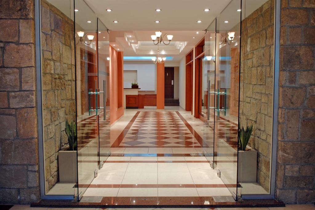 a hallway in a building with a glass corridor at Pyramos Hotel in Paphos City