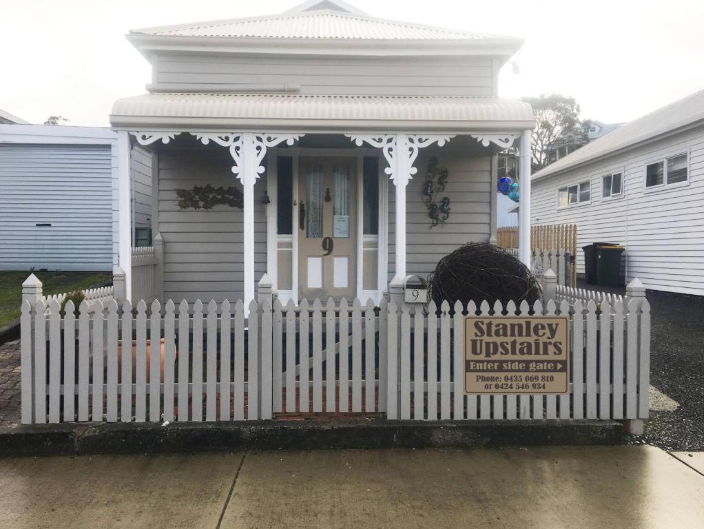 a white picket fence in front of a white house at Stanley-upstairs in Stanley