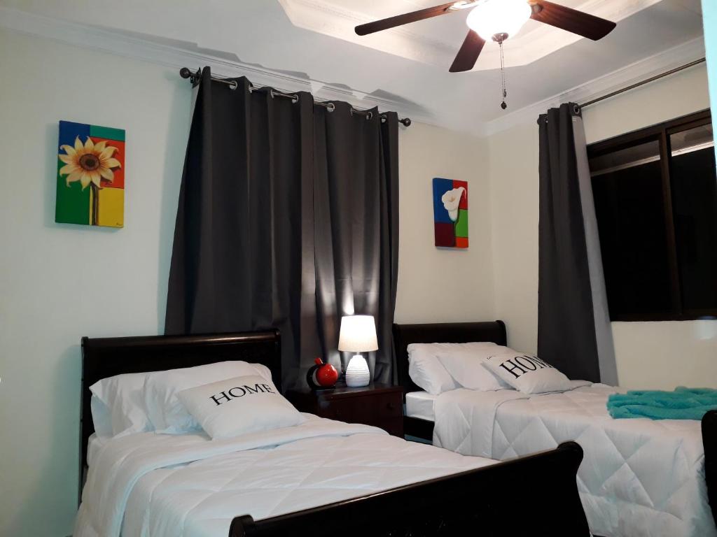 a bedroom with two beds and a ceiling fan at Casa Mirango Boquete in Boquete