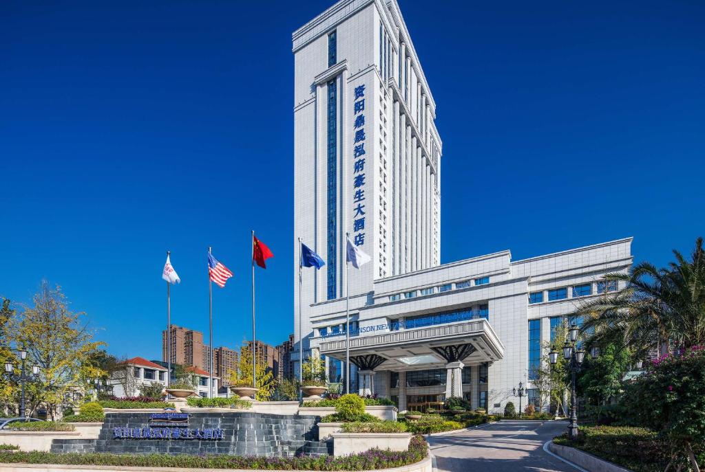 资阳资阳鼎晟泓府豪生大酒店 的前面有两面美国国旗的高楼