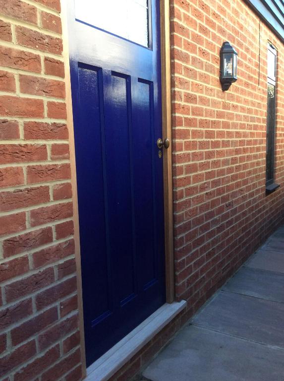 a blue door on the side of a brick building at Passengers House in Whitstable