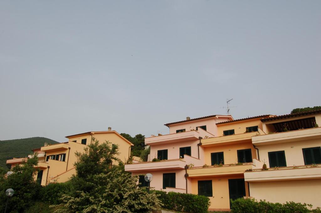 a row of apartment buildings on a hill with trees at Solanha molocale 01 in Cavo