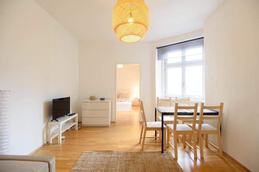 jadalnia ze stołem, krzesłami i telewizorem w obiekcie Central Living Apartment 1090 Vienna w Wiedniu