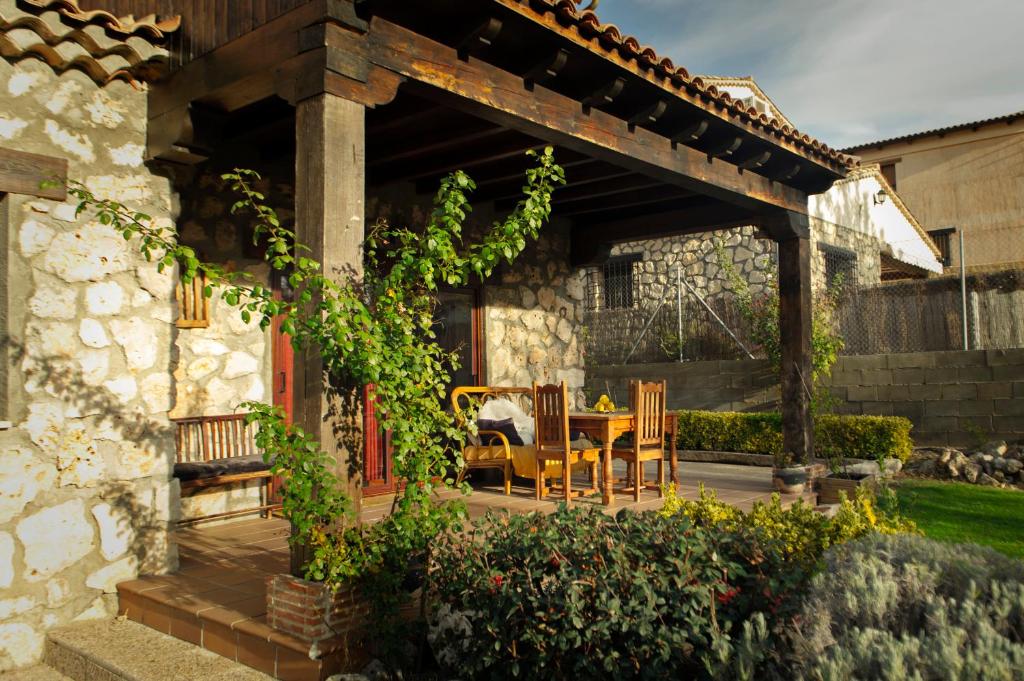 eine Terrasse mit einem Tisch und Stühlen unter einer Pergola in der Unterkunft Casa Rural La Loma in Nohales