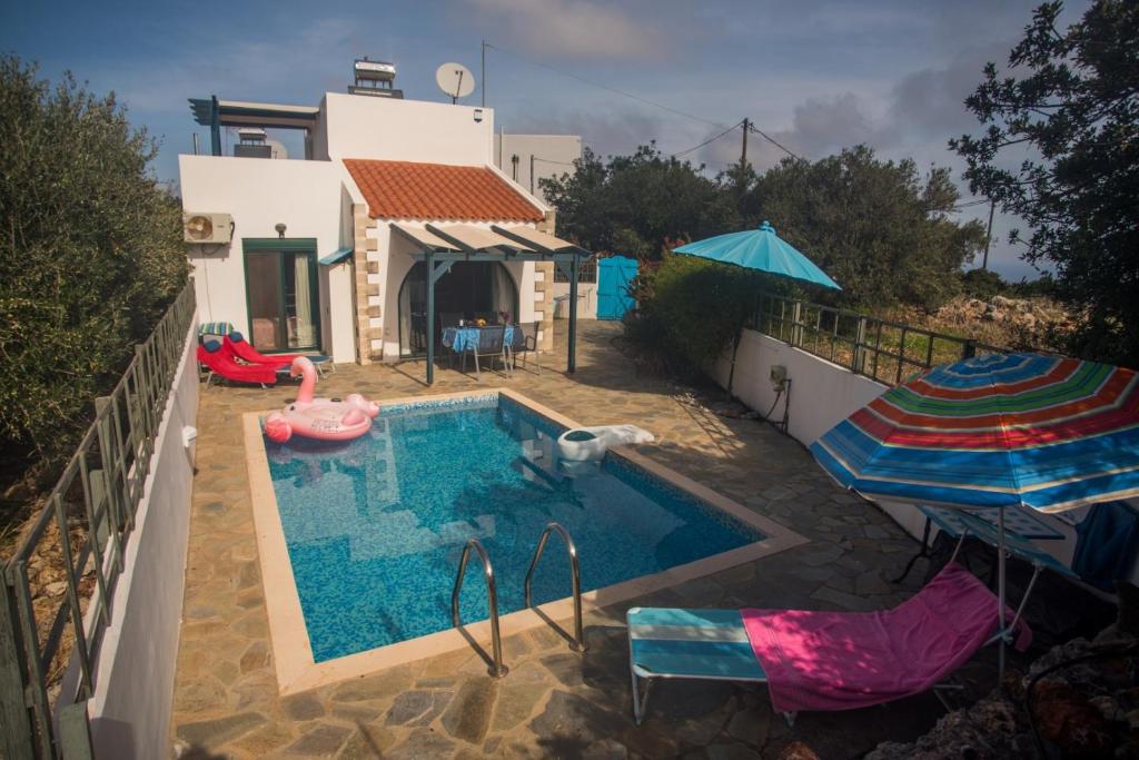 a house with a swimming pool and a house with an umbrella at Villa Afou in Afráta