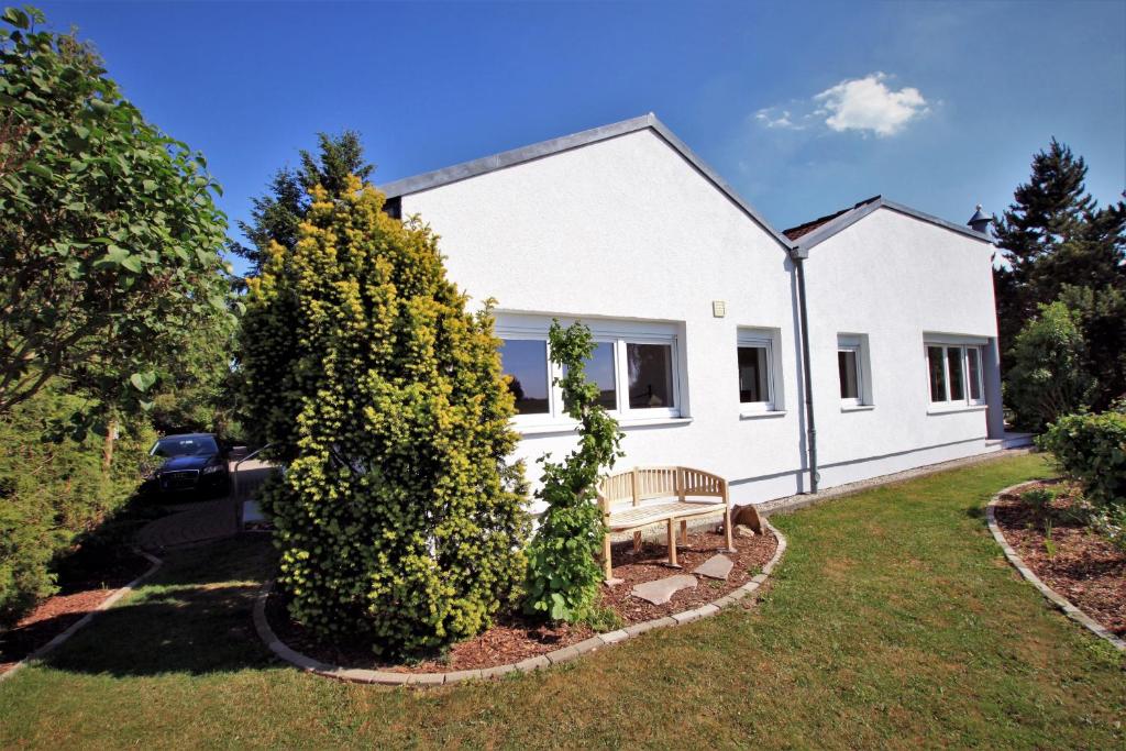 una casa blanca con un banco en el patio en Ferienhaus Vera en Moritzburg