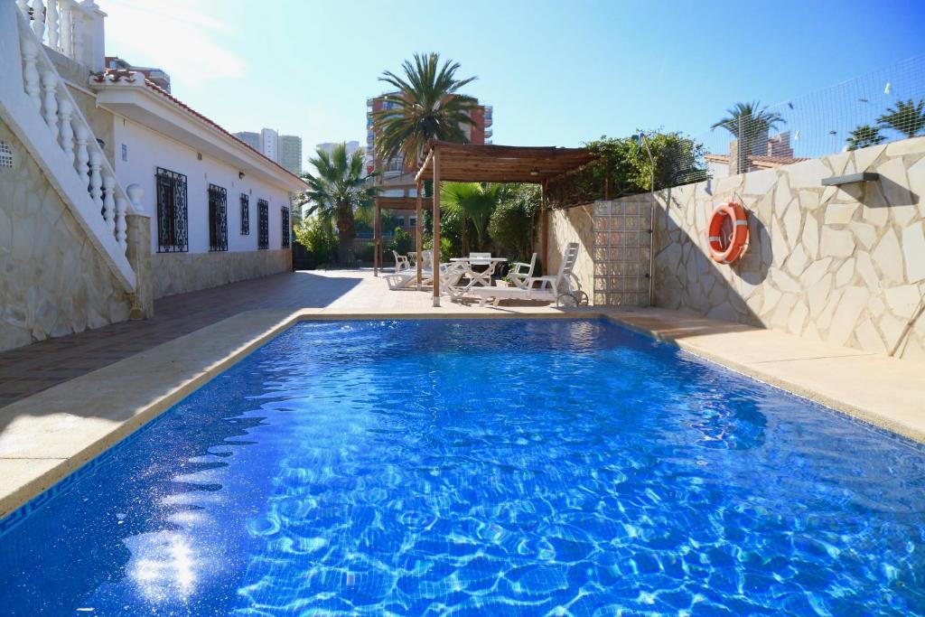 a swimming pool with blue water in a house at Villa Ana Apartments in Benidorm