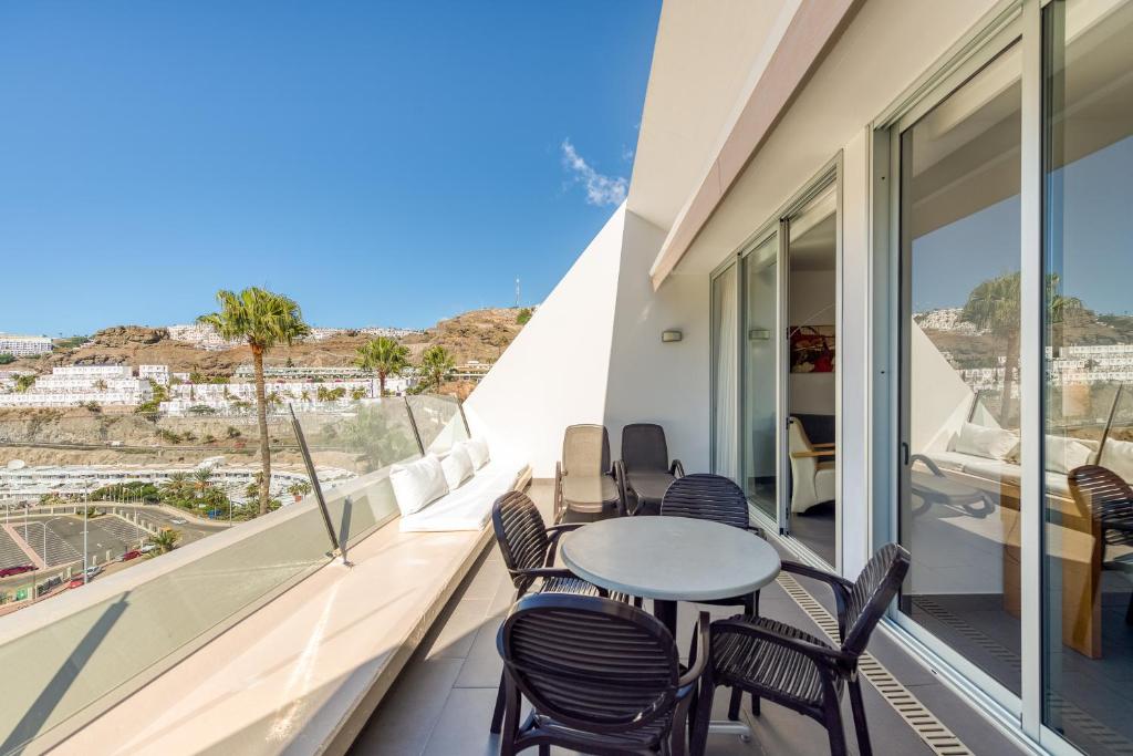 a balcony with chairs and a table with a view at Holiday Club Puerto Calma in Puerto Rico de Gran Canaria
